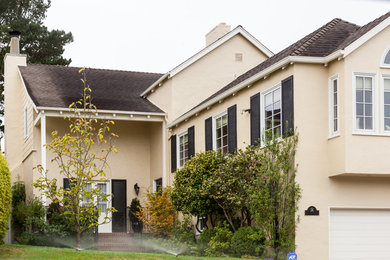 Elegant beige two-story stucco exterior home photo in San Francisco with a shingle roof