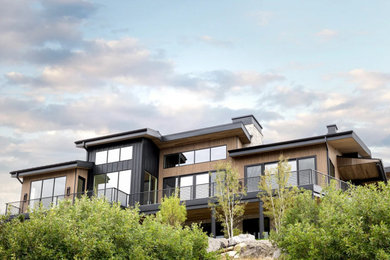 Large contemporary brown two-story wood and board and batten house exterior idea in Salt Lake City with a shed roof, a metal roof and a gray roof