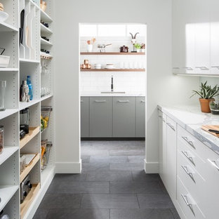 Пример оригинального дизайна: п-образная кухня среднего размера в современном стиле с кладовкой, плоскими фасадами, серым полом, белыми фасадами, мраморной столешницей, белым фартуком, фартуком из плитки кабанчик и полом из сланца без острова