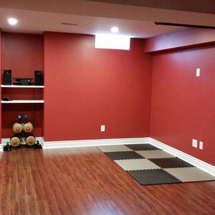 トロントの中サイズのコンテンポラリースタイルのおしゃれな多目的ジム (赤い壁、無垢フローリング、茶色い床) の写真