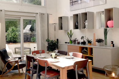 Cette photo montre une grande salle à manger tendance avec un mur blanc et parquet clair.