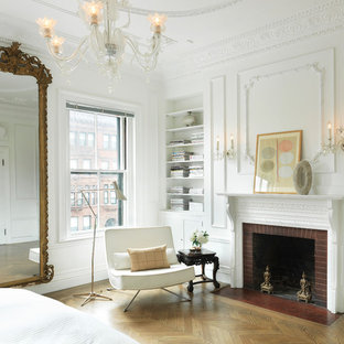 Idées déco pour une chambre victorienne avec un mur blanc, un sol en bois brun, une cheminée standard et un manteau de cheminée en brique.