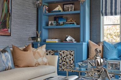 Large transitional built-in desk carpeted home office library photo in Miami with blue walls