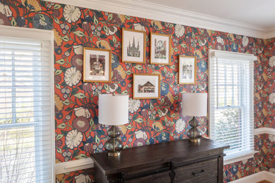 Example of a mid-sized eclectic medium tone wood floor and wallpaper enclosed dining room design in Raleigh with multicolored walls
