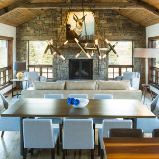 Design ideas for a country open plan dining in Other with white walls, medium hardwood floors, a standard fireplace and a stone fireplace surround.