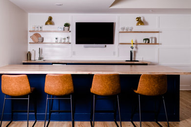 Exemple d'un grand bar de salon avec évier parallèle avec un évier posé, un placard à porte shaker, des portes de placard bleues, un plan de travail en bois, une crédence blanche et un sol en vinyl.