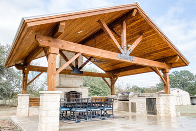 Inspiration for a large craftsman backyard concrete patio kitchen remodel in Austin with a gazebo