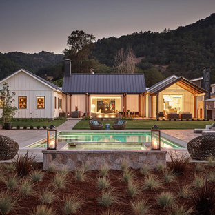 Выдающиеся фото от архитекторов и дизайнеров интерьера: одноэтажный фасад частного дома белого цвета в стиле кантри с двускатной крышей и металлической крышей