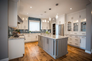 Inspiration for a mid-sized transitional u-shaped light wood floor enclosed kitchen remodel in Other with an undermount sink, shaker cabinets, white cabinets, granite countertops, multicolored backsplash, matchstick tile backsplash, stainless steel appliances and an island