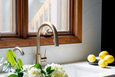Mid-sized mid-century modern galley terra-cotta tile and red floor eat-in kitchen photo in Chicago with an undermount sink, flat-panel cabinets, black cabinets, quartz countertops, white backsplash, quartz backsplash, black appliances and white countertops