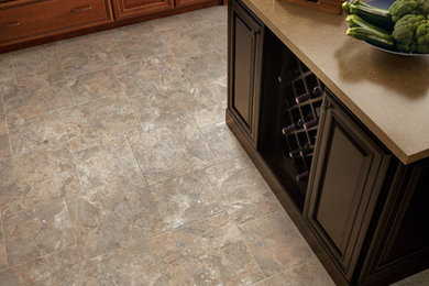 Large elegant vinyl floor enclosed kitchen photo in Orange County with a double-bowl sink, raised-panel cabinets, medium tone wood cabinets, stainless steel appliances and an island