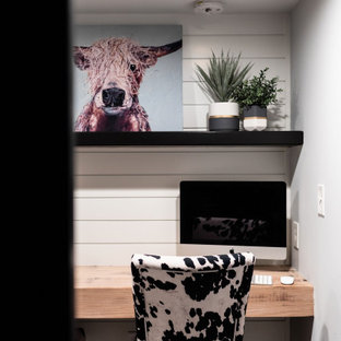 Kleines Landhausstil Arbeitszimmer mit weißer Wandfarbe, Teppichboden, Einbau-Schreibtisch, grauem Boden und Holzdielenwänden in Minneapolis