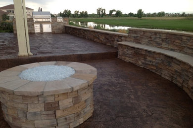 Inspiration for a large southwestern backyard stamped concrete patio kitchen remodel in Denver with no cover
