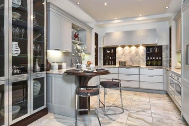 Kitchen - mid-sized transitional u-shaped kitchen idea in Miami with an undermount sink, flat-panel cabinets, gray cabinets, granite countertops, gray backsplash, stone slab backsplash and paneled appliances