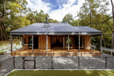Ejemplo de fachada de casa negra y gris de tamaño medio de dos plantas con revestimiento de madera, tejado a dos aguas, tejado de metal y panel y listón