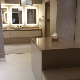 Inspiration for a large modern gender-neutral limestone floor dressing room remodel in Miami with flat-panel cabinets and beige cabinets