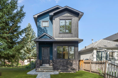 Example of a mid-sized classic blue two-story mixed siding exterior home design in Calgary with a black roof
