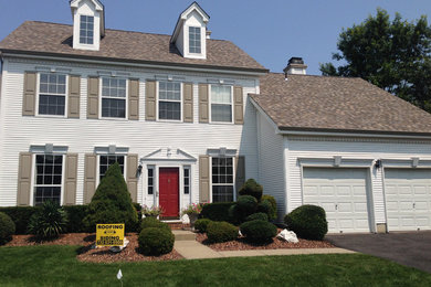 Example of a large classic brown two-story vinyl exterior home design in New York with a gambrel roof