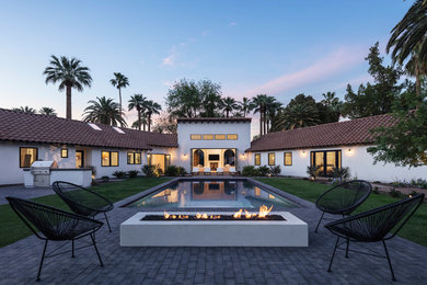 Example of a mid-sized trendy white one-story stucco house exterior design in Phoenix with a tile roof