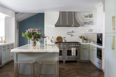 Inspiration for a transitional u-shaped dark wood floor and brown floor kitchen remodel in Los Angeles with shaker cabinets, green cabinets, white backsplash, stainless steel appliances, an island and white countertops