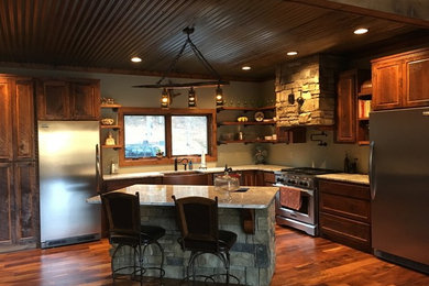 Inspiration for a mid-sized craftsman l-shaped medium tone wood floor and brown floor eat-in kitchen remodel in Atlanta with a farmhouse sink, recessed-panel cabinets, medium tone wood cabinets, granite countertops, stainless steel appliances and an island