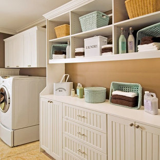 Medium sized rural single-wall separated utility room in Philadelphia with shaker cabinets, white cabinets, ceramic flooring, a side by side washer and dryer and brown walls.