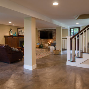 シアトルの中サイズのおしゃれな地下室 (半地下 (ドアあり)、ベージュの壁、コンクリートの床、タイルの暖炉まわり、グレーの床、標準型暖炉) の写真