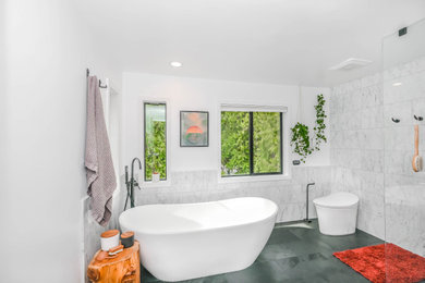 Mid-sized minimalist master white tile and porcelain tile ceramic tile, gray floor and double-sink bathroom photo in New York with flat-panel cabinets, brown cabinets, a one-piece toilet, white walls, an undermount sink, quartzite countertops, a hinged shower door, white countertops and a freestanding vanity