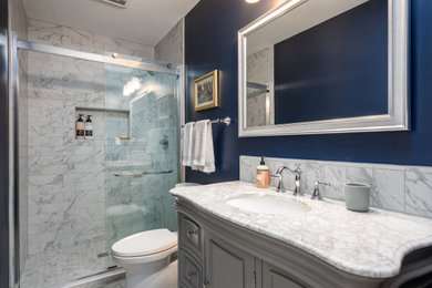 Bathroom - small traditional 3/4 gray tile and subway tile ceramic tile, gray floor and single-sink bathroom idea in Grand Rapids with raised-panel cabinets, gray cabinets, a two-piece toilet, blue walls, an undermount sink, granite countertops, gray countertops and a freestanding vanity
