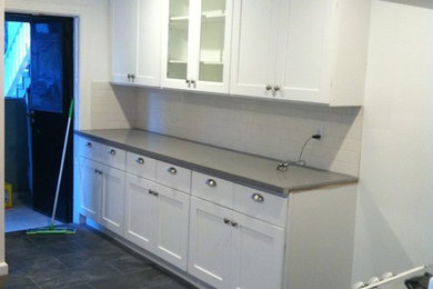 Small trendy galley porcelain tile enclosed kitchen photo in Los Angeles with a double-bowl sink, shaker cabinets, white cabinets, quartzite countertops, white backsplash, ceramic backsplash, stainless steel appliances and no island