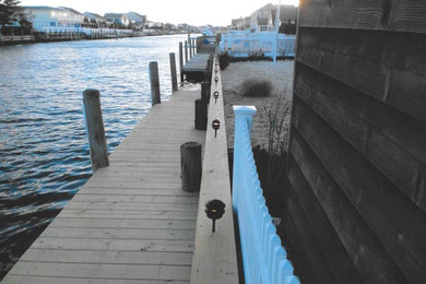 Example of a mid-sized island style backyard dock design in Other with no cover
