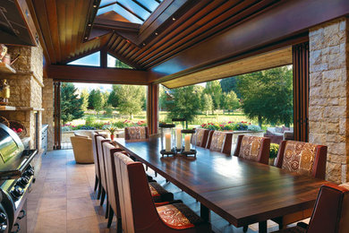 Patio kitchen - huge rustic backyard tile patio kitchen idea in Denver with a roof extension
