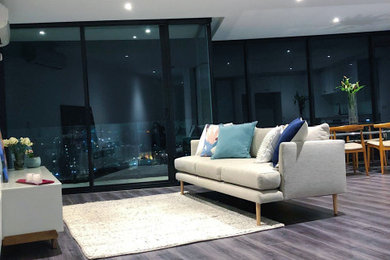 This is an example of a small modern open concept living room in Melbourne with laminate floors and grey floor.