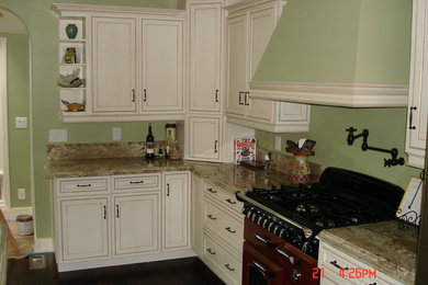 Tuscan medium tone wood floor kitchen photo in Los Angeles with an undermount sink, recessed-panel cabinets, white cabinets, granite countertops, beige backsplash, stone slab backsplash and stainless steel appliances