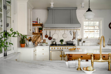 Inspiration for a mid-sized french country u-shaped light wood floor, gray floor and shiplap ceiling eat-in kitchen remodel in Toronto with a farmhouse sink, recessed-panel cabinets, white cabinets, marble countertops, white backsplash, subway tile backsplash, paneled appliances, two islands and white countertops