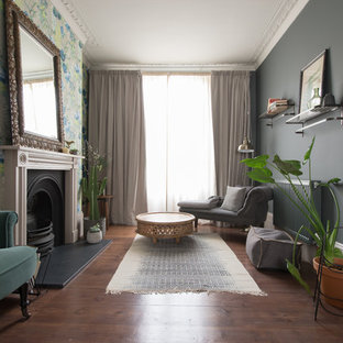 Inspiration for a medium sized classic family and games room in London with blue walls, medium hardwood flooring, a standard fireplace, a metal fireplace surround and brown floors.