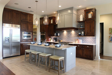 Example of a mid-sized transitional l-shaped ceramic tile open concept kitchen design in Austin with an undermount sink, flat-panel cabinets, medium tone wood cabinets, blue backsplash, subway tile backsplash, stainless steel appliances and an island