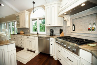 Kitchen - large traditional dark wood floor kitchen idea in St Louis with an undermount sink, raised-panel cabinets, white cabinets, granite countertops, beige backsplash, ceramic backsplash, stainless steel appliances and an island