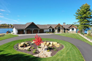 Example of a large trendy two-story mixed siding house exterior design in Other with a shingle roof and a brown roof