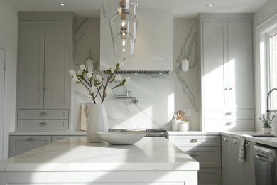 Large trendy u-shaped light wood floor and gray floor eat-in kitchen photo in Toronto with a single-bowl sink, shaker cabinets, gray cabinets, quartz countertops, white backsplash, stone slab backsplash, stainless steel appliances and an island