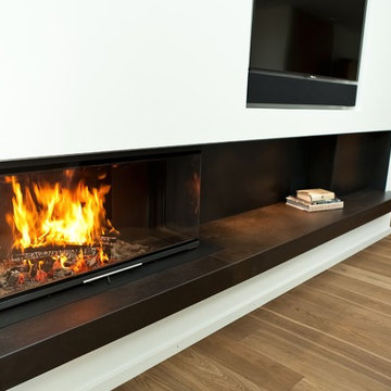 Holzkamin & in die Wand integrierte Holzlege für moderne Dachgeschosswohnung