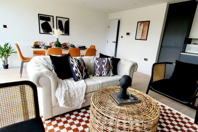 This is an example of a contemporary open plan living room feature wall with white walls, a freestanding tv, beige floors and wallpapered walls.