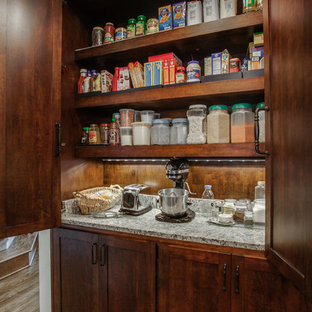 Mid-sized traditional u-shaped kitchen pantry in Dallas with a single-bowl sink, shaker cabinets, dark wood cabinets, granite benchtops, beige splashback, stone tile splashback, stainless steel appliances, medium hardwood floors and with island.