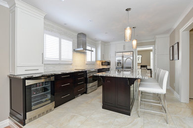 Large transitional u-shaped ceramic tile enclosed kitchen photo in Toronto with an undermount sink, flat-panel cabinets, dark wood cabinets, granite countertops, beige backsplash, matchstick tile backsplash, stainless steel appliances and an island