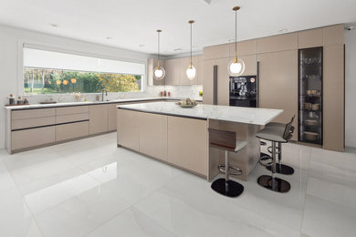 Large trendy l-shaped ceramic tile and white floor eat-in kitchen photo in New York with an undermount sink, flat-panel cabinets, beige cabinets, quartz countertops, white backsplash, quartz backsplash, black appliances, an island and white countertops