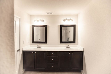 Bathroom - large traditional master laminate floor and beige floor bathroom idea in Other with recessed-panel cabinets, dark wood cabinets, beige walls, an integrated sink, solid surface countertops and white countertops