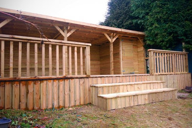 Bespoke timber canopy with polycarbonate roof and log lap screen.