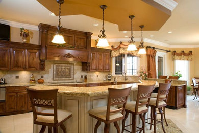Inspiration for a large rustic u-shaped slate floor eat-in kitchen remodel in Chicago with an undermount sink, raised-panel cabinets, dark wood cabinets, granite countertops, beige backsplash, stone tile backsplash, stainless steel appliances and an island