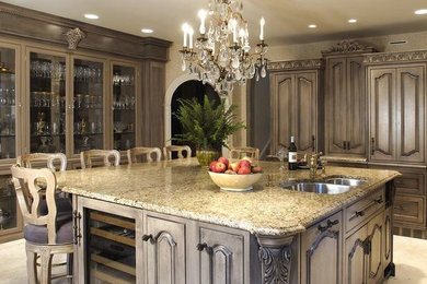Example of a large classic eat-in kitchen design in San Diego with a double-bowl sink, raised-panel cabinets, light wood cabinets, granite countertops, stainless steel appliances and an island
