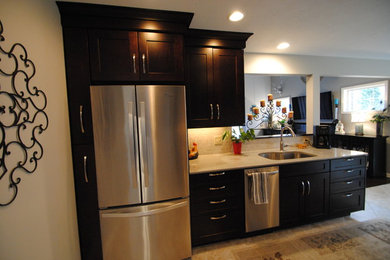 Mid-sized elegant galley ceramic tile eat-in kitchen photo in Cleveland with shaker cabinets, dark wood cabinets, beige backsplash, stainless steel appliances, an undermount sink, quartzite countertops, ceramic backsplash and no island
